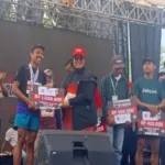 Penyerahan hadiah kepada para pemenang kategori umum Merdeka Coffee Trail Run di Embung Gogoniti, Kabupaten Blitar, Minggu (23/8/2026).